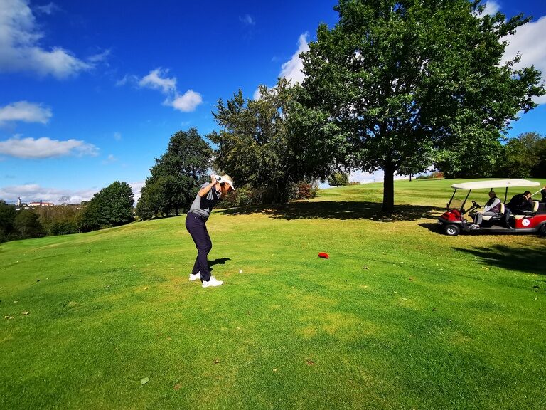 Ein Golfer schwingt seinen Schläger beim Abschlag auf der hauseigenen Golfanlage des Hotel Anetseder.